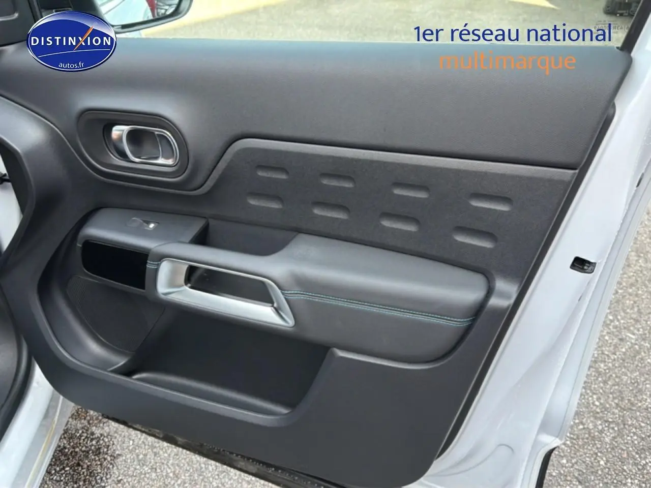 Vue rapprochée de la porte avant droite blanche d’un Citroën C5 Aircross 2025 avec garniture noire et poignée argentée.