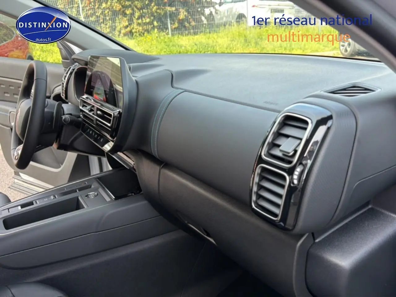 Vue intérieure côté passager du tableau de bord noir et gris avec écran tactile du Citroën C5 Aircross blanc 2025.