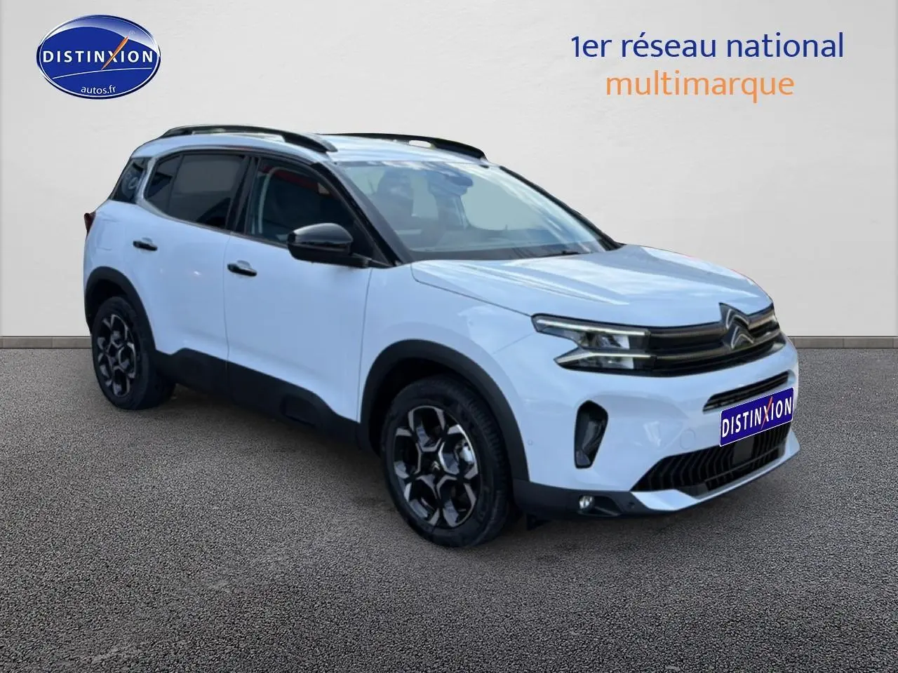Citroën C5 Aircross blanc vue 3/4 avant droit avec jantes noires et barres de toit visibles.
