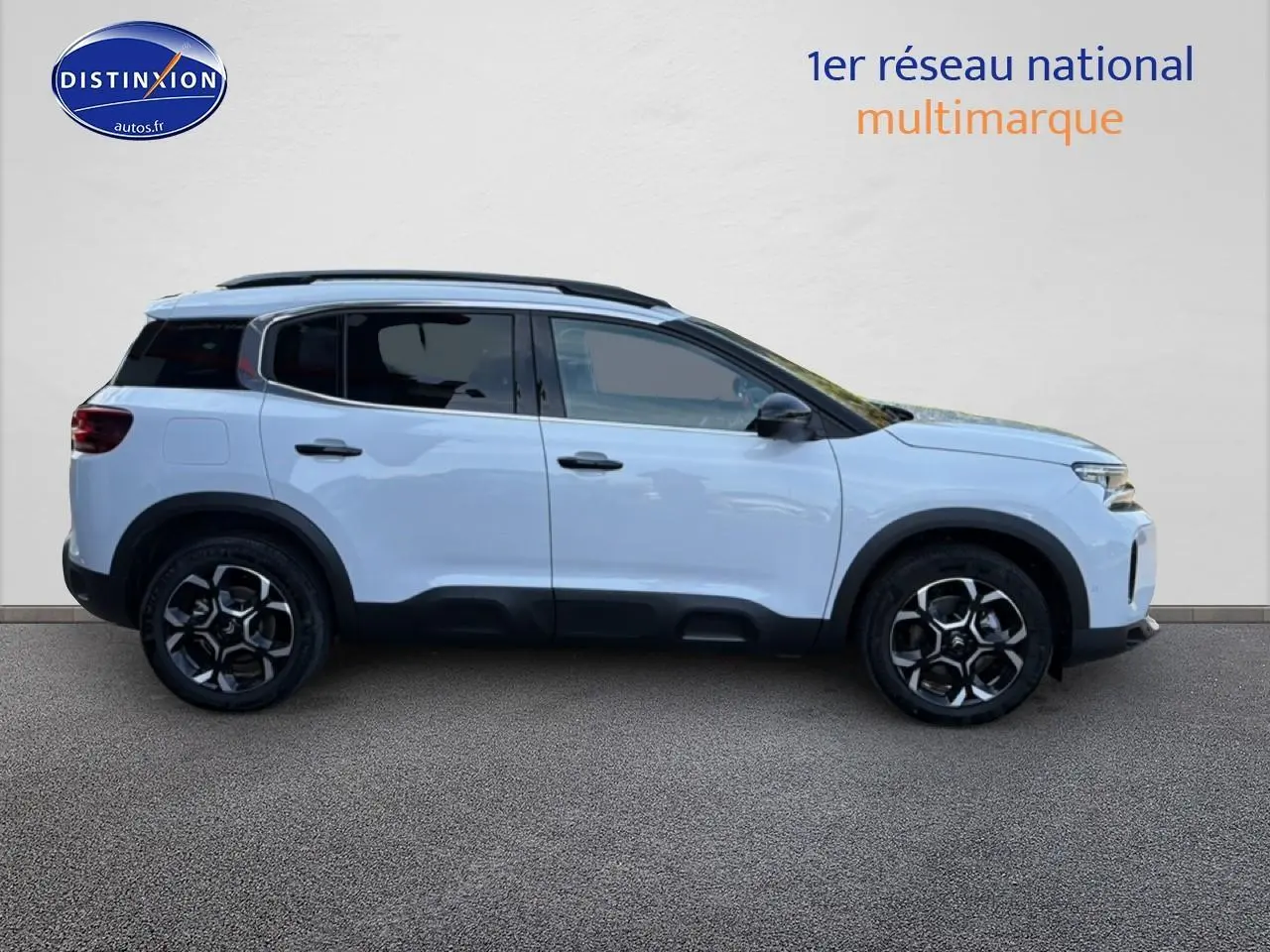 Profil droit d'un Citroën C5 Aircross blanc 2025 avec barres de toit et jantes alliage noires.