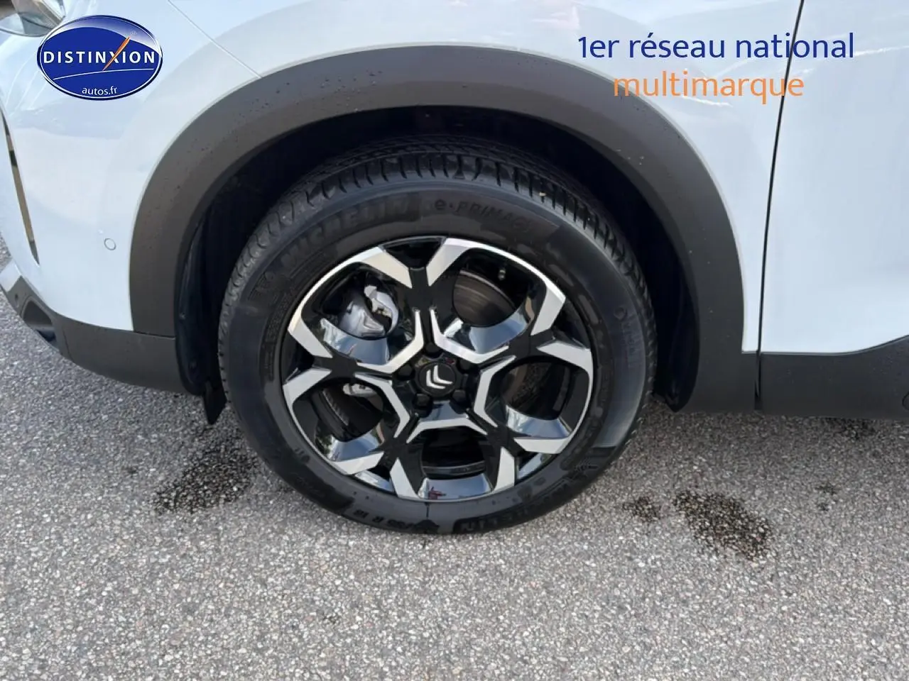 Gros plan sur la roue avant gauche d’un Citroën C5 Aircross blanc avec jante alu noire et argentée.