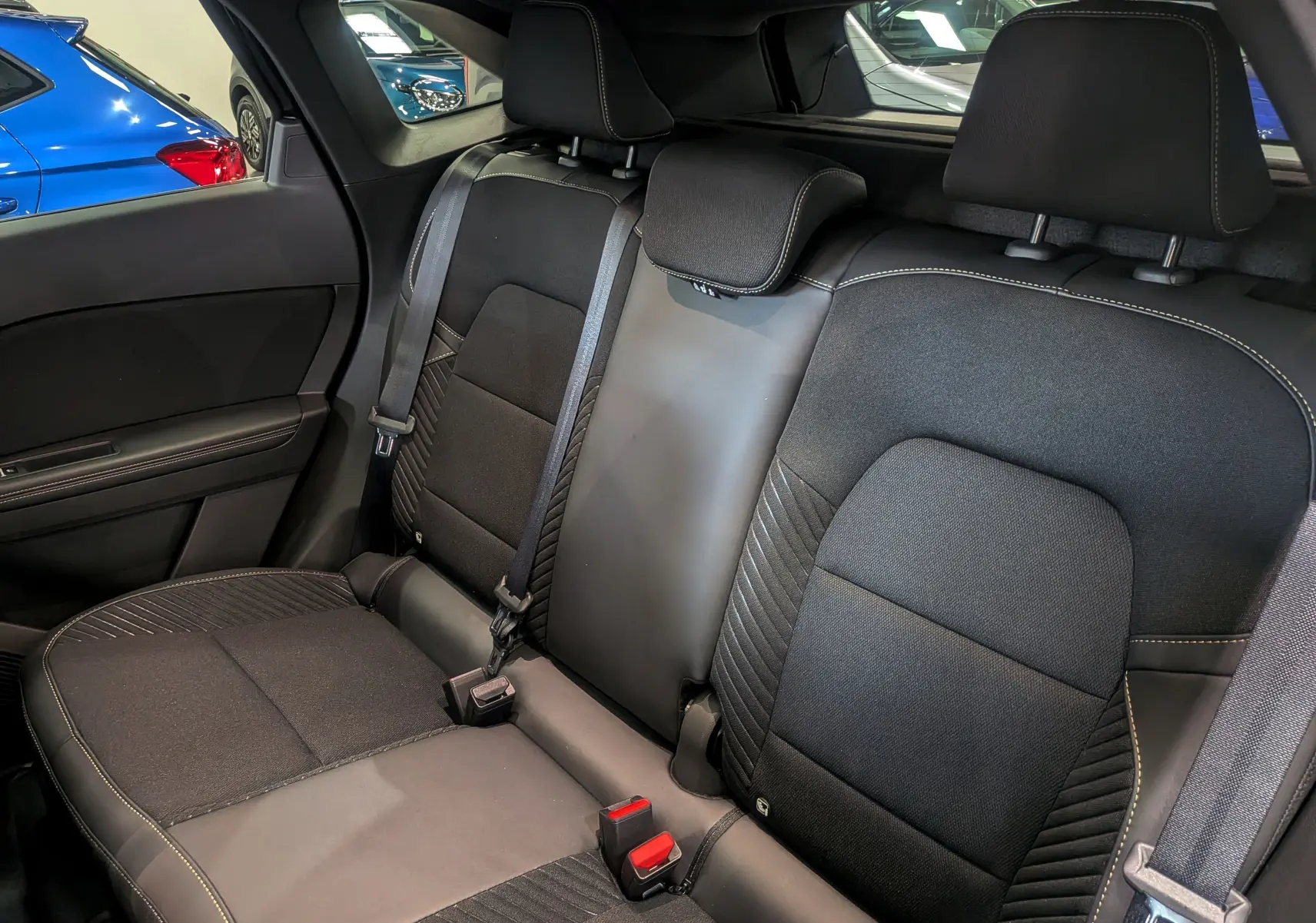 Vue intérieure de la banquette arrière du Renault Symbioz noir étoilé, avec sièges en tissu et cuir noir.