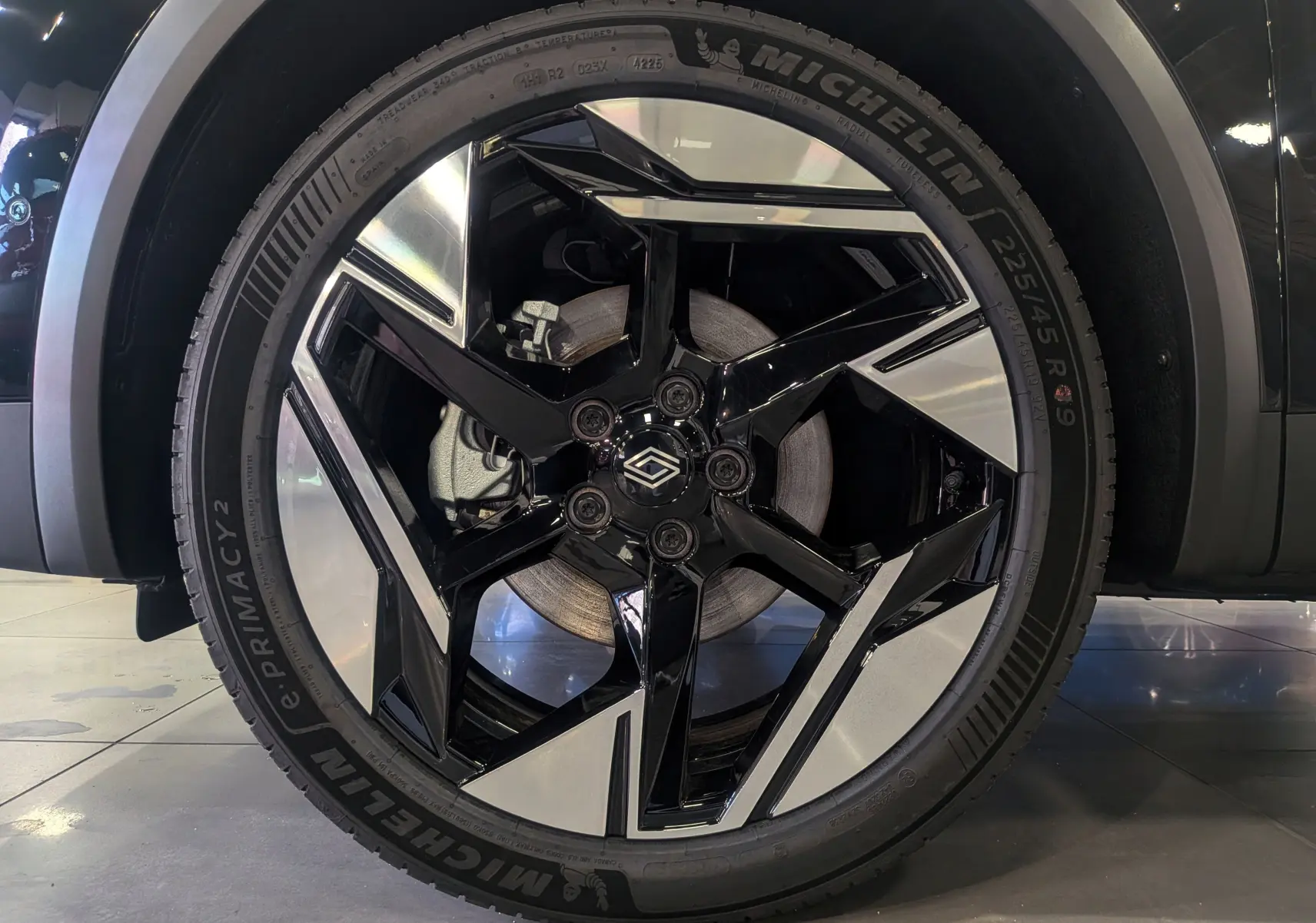 Gros plan sur la jante bi-ton noire et argentée Michelin d’un Renault SYMBIOZ noir étoilé, version E-Tech hybride.