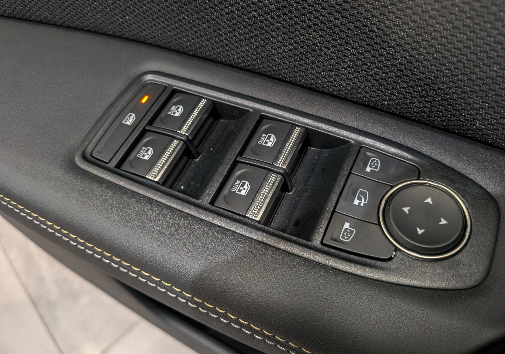 Gros plan sur les commandes de lève-vitres et réglages des rétroviseurs côté gauche du Renault Symbioz noir étoilé.