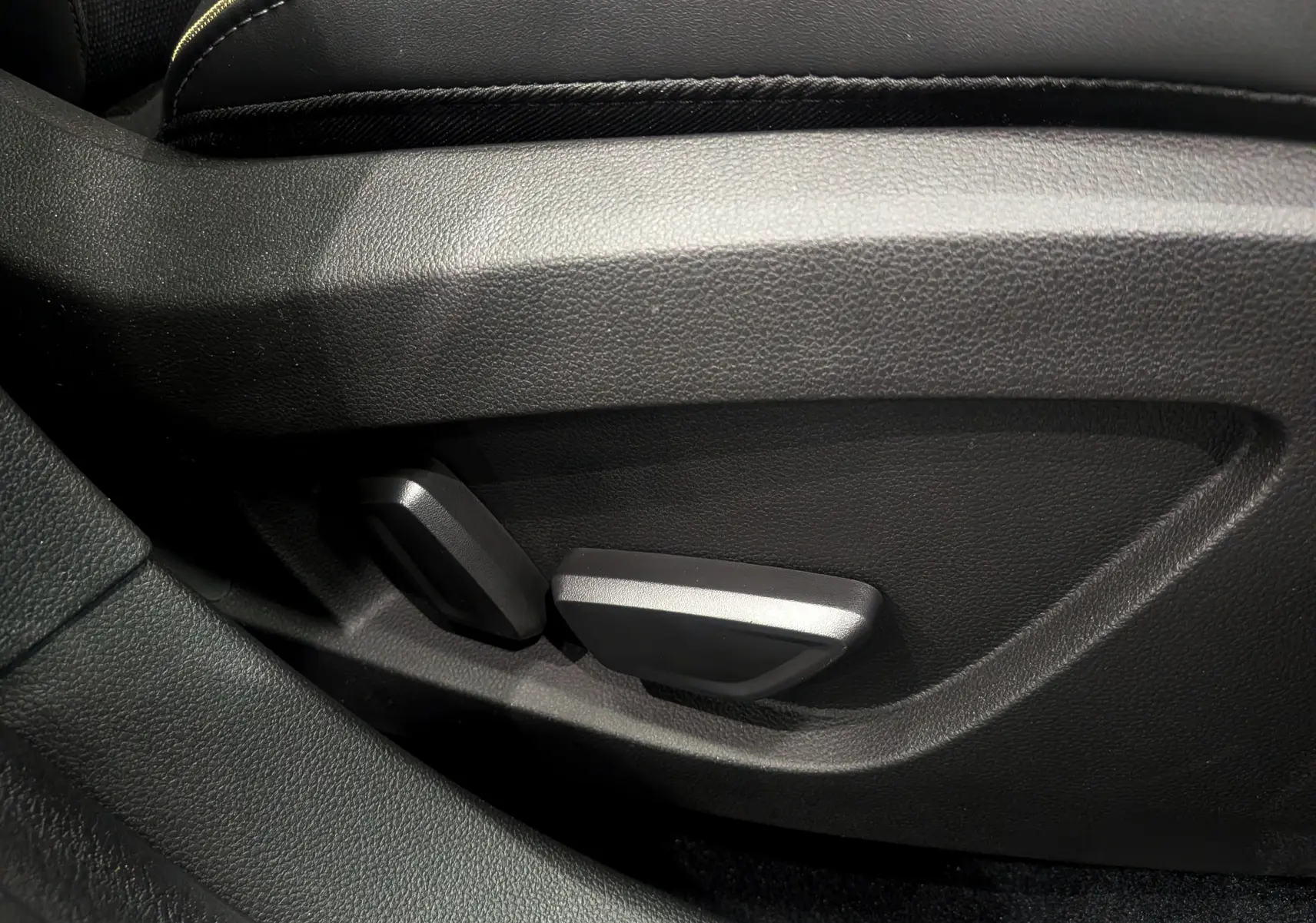Gros plan sur les commandes de réglage électrique du siège avant noir du Renault Symbioz E-Tech hybride 2026.