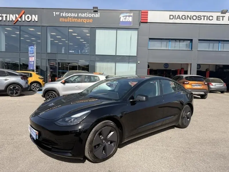 Tesla Model 3 Standard RWD Plus noir vue 3/4 avant droit, avec jantes spécifiques et carrosserie électrique brillante.
