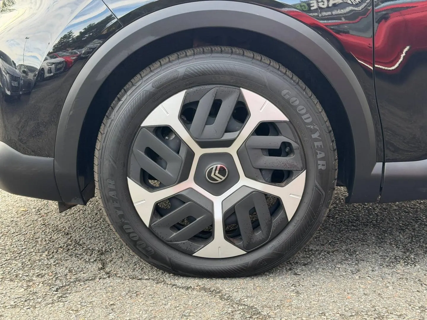 Gros plan sur la roue avant droite noire Perla Nera d'une Citroën C4 1.2 Hybride avec jante alu bicolore.