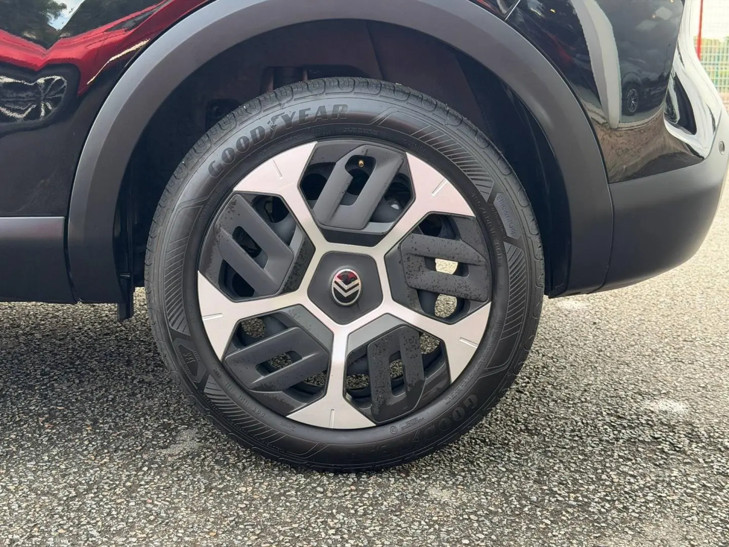 Gros plan sur la roue avant droite noire Perla Nera du Citroën C4 1.2 Hybride 145ch avec jante alu distinctive.