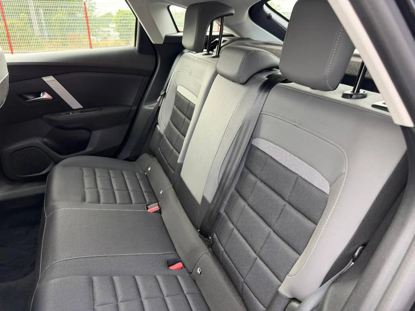 Vue côté droit de la banquette arrière noire et grise du Citroën C4 1.2 Hybride 145ch 2025 avec ceinture de sécurité.