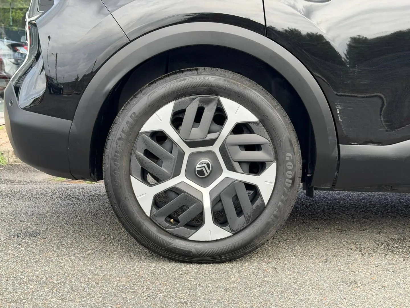 Gros plan sur la roue arrière droite noire Perla Nera d'une Citroën C4 1.2 Hybride avec jante alu distinctive.