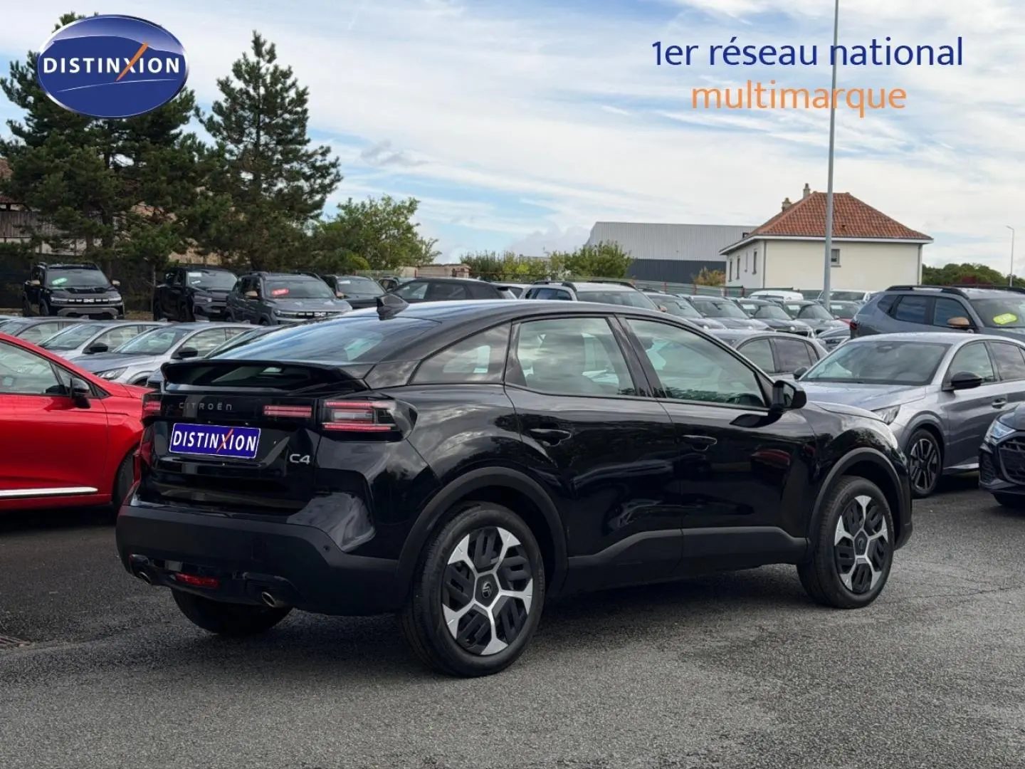 Vue 3/4 arrière droite d'une Citroën C4 noire Perla Nera avec jantes alu et feux arrière LED dans un parking.