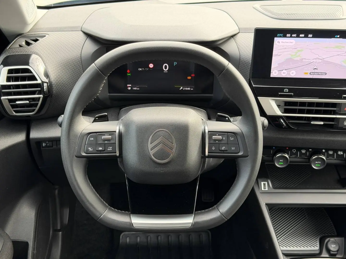 Vue frontale du volant cuir noir et du tableau de bord numérique de la Citroën C4 1.2 Hybride 2025 avec écran tactile GPS.