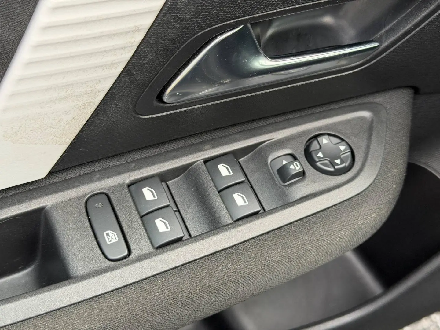 Gros plan sur les commandes de lève-vitres et rétroviseurs côté conducteur d'une Citroën C4 noire.