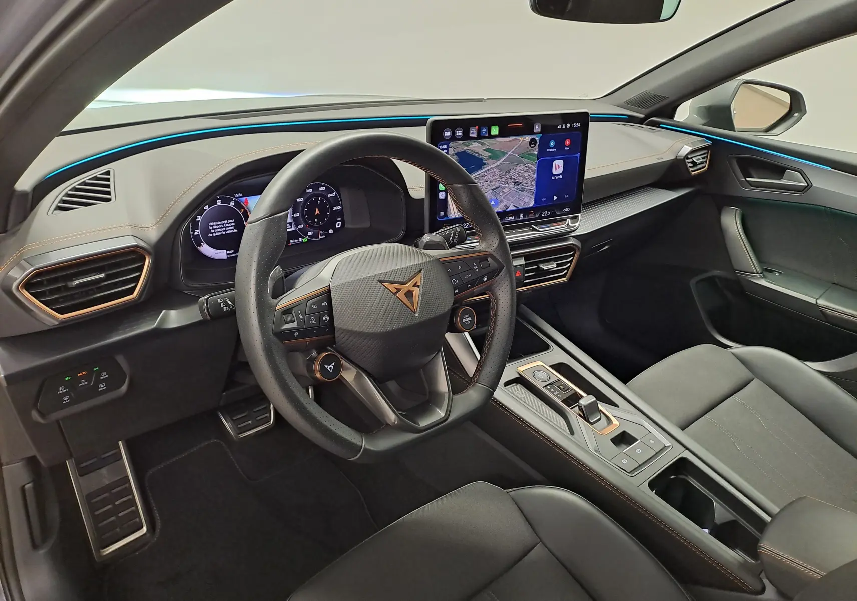 Vue intérieure côté conducteur de la CUPRA Leon 1.5 eTSI 2025 avec tableau de bord numérique et toit ouvrant panoramique.