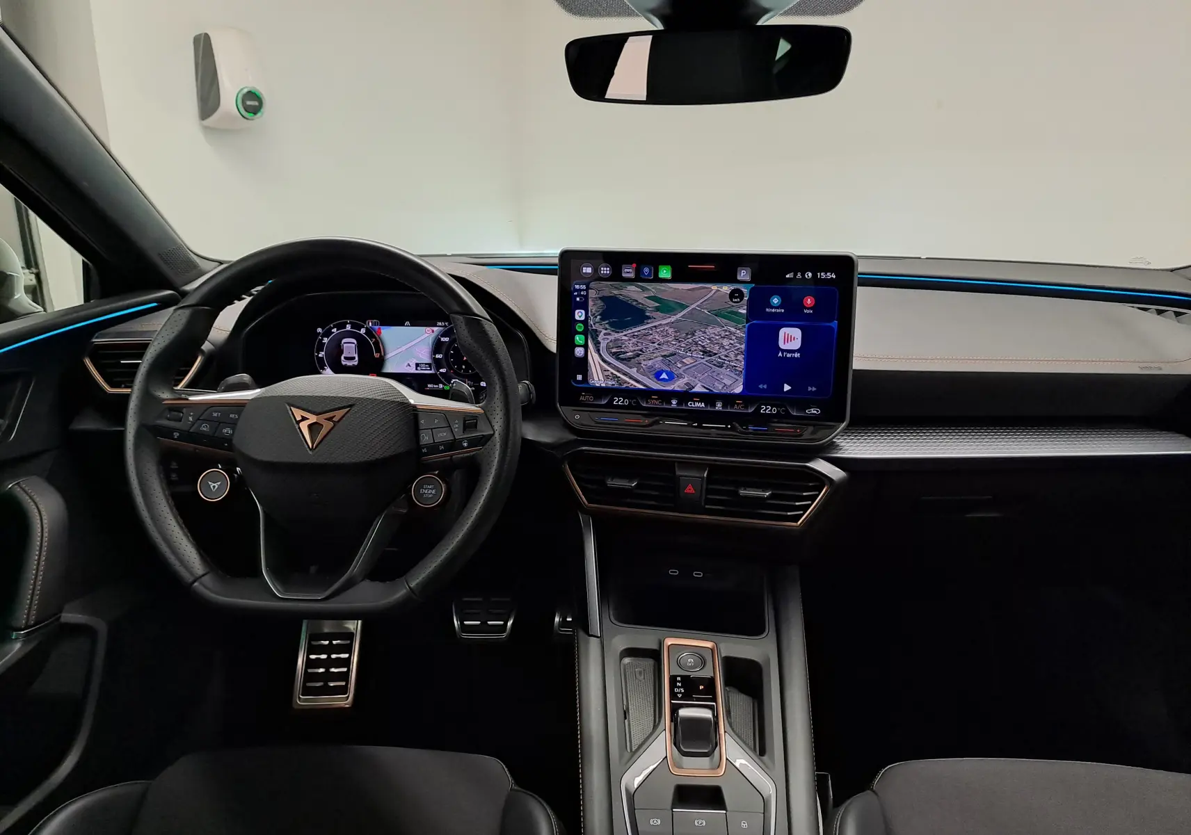Vue intérieure avant du CUPRA Leon 1.5 eTSI 2025 avec tableau de bord numérique et écran tactile central lumineux.
