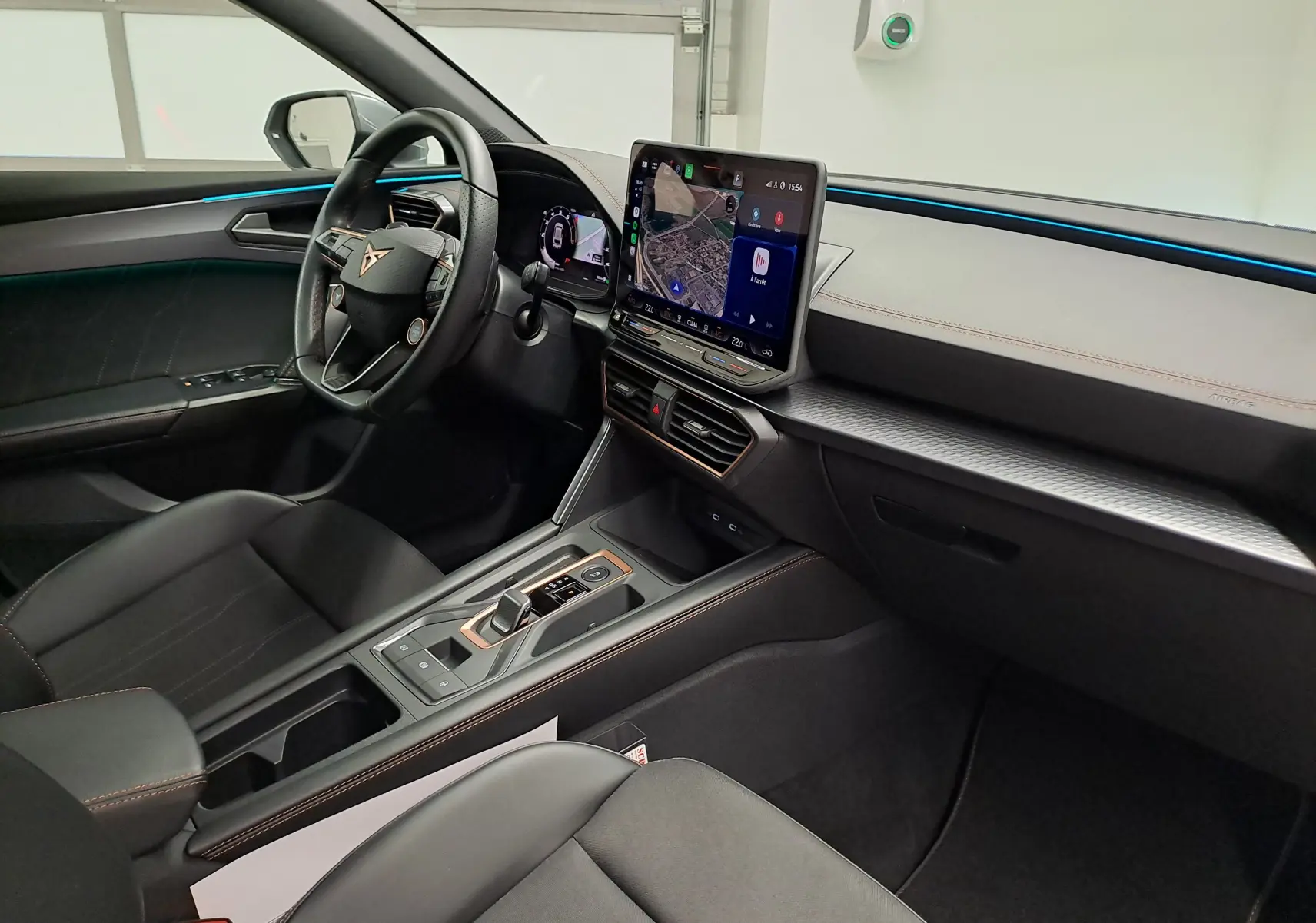 Vue intérieure côté conducteur de la CUPRA Leon 2025 avec tableau de bord numérique et écran tactile central.