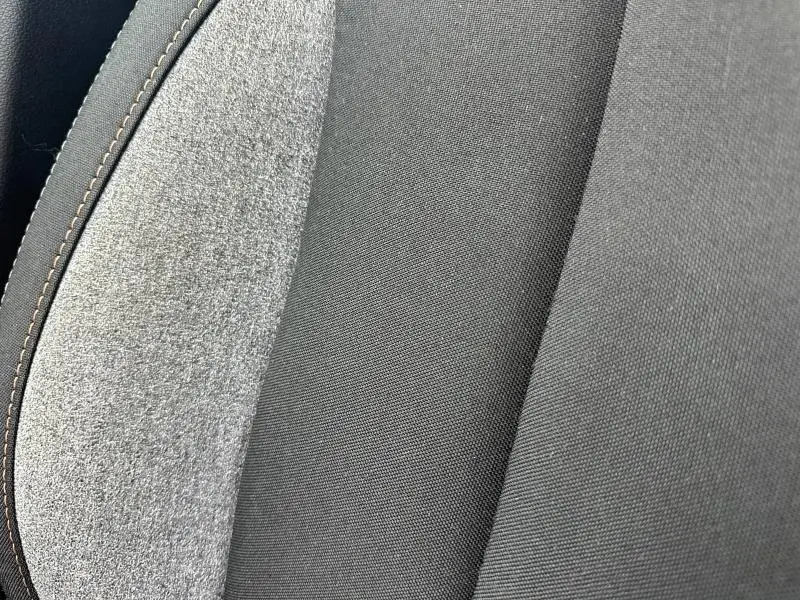 Détail du tissu noir et gris recyclé du siège avant du Skoda Scala 2025, souligné par une couture beige.