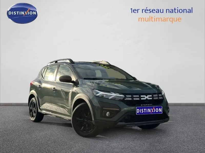 Vue 3/4 avant d'une Dacia Sandero Stepway 2025 en kaki lichen avec jantes noires et toit surélevé.