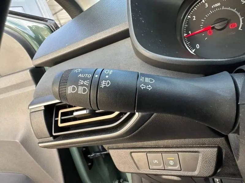 Gros plan sur la commande des feux et clignotants dans l'habitacle kaki lichen de la Dacia Sandero Stepway 2025.
