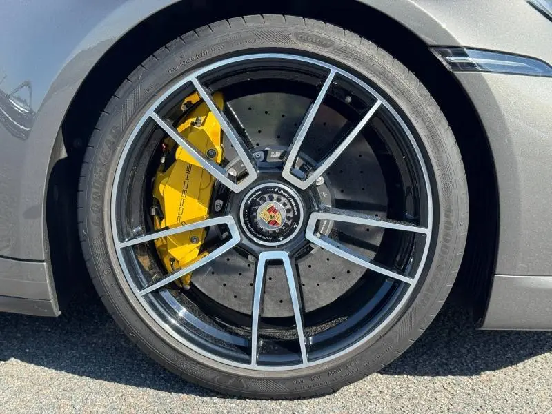 Gros plan sur la roue avant droite grise d'une Porsche 911 Turbo S 2020 avec étrier de frein jaune marqué Porsche.