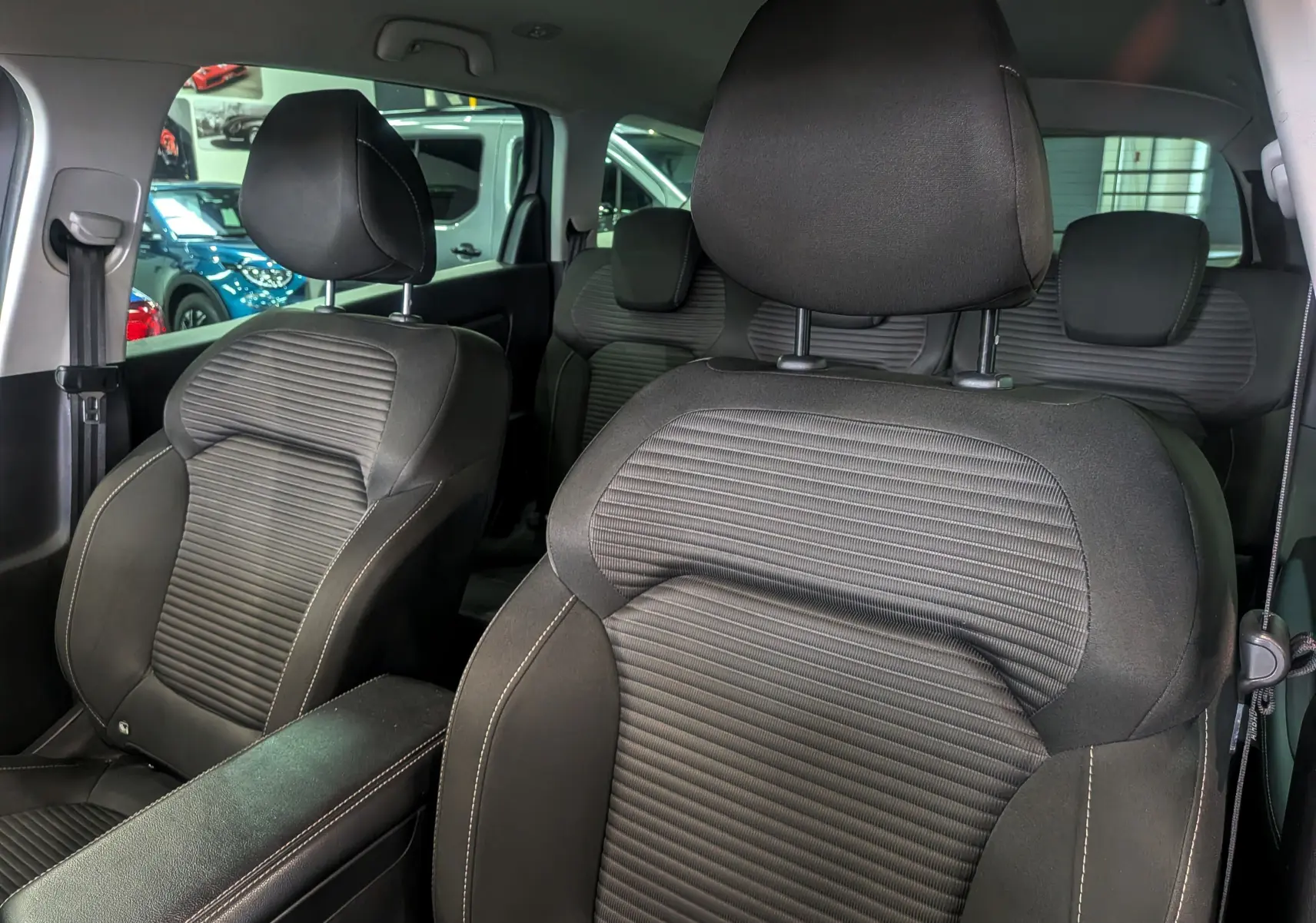 Vue intérieure rapprochée des sièges avant en tissu gris foncé du Renault Grand Scenic IV, version TCe 140 CH EDC Evolution.