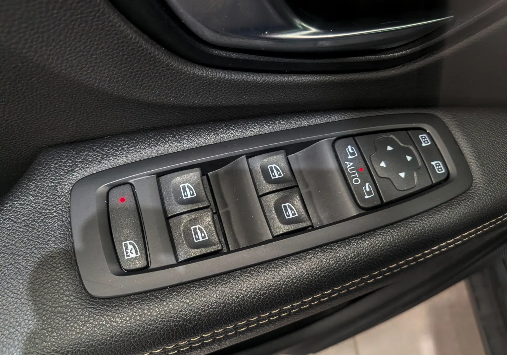 Gros plan sur les commandes de lève-vitres et rétroviseurs électriques du Renault Grand Scenic IV, finition tissu noire.