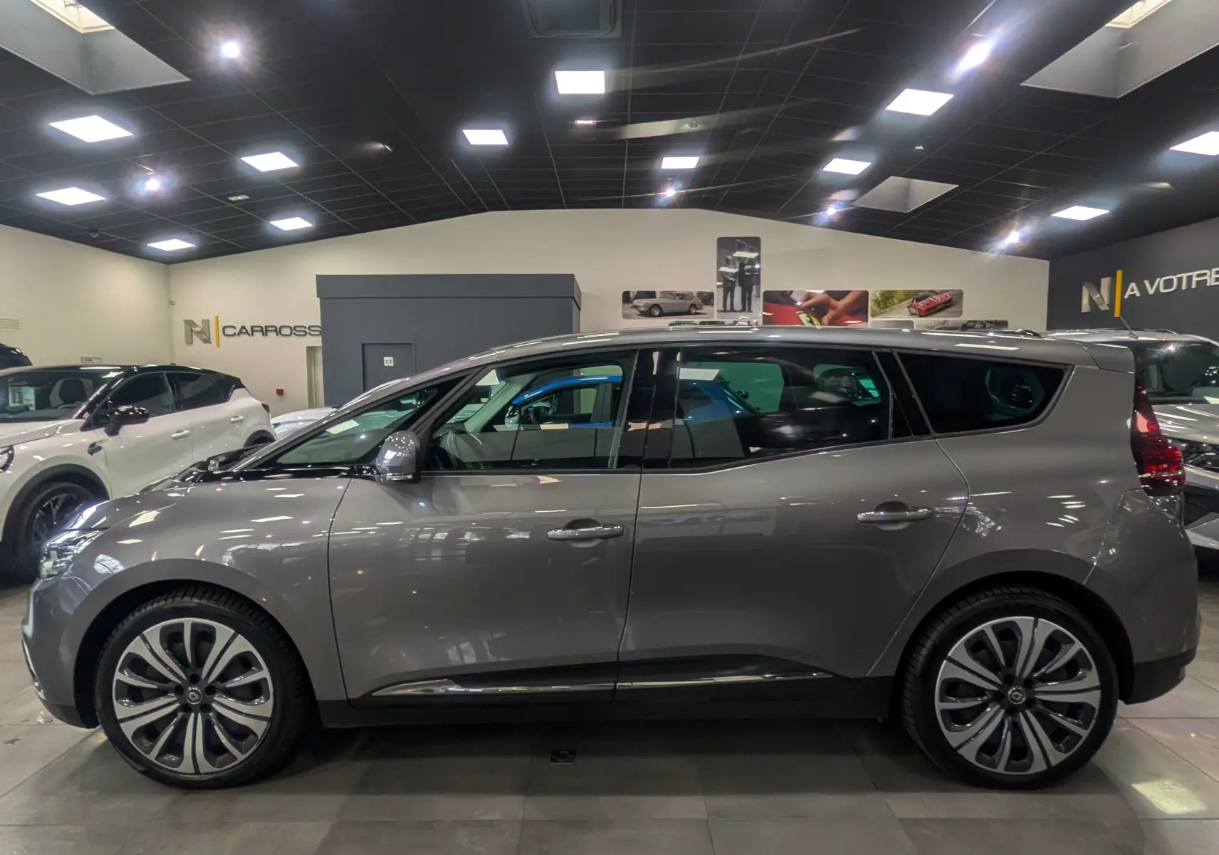 Renault Grand Scénic IV TCe 140 gris Cassiopé, vue de profil côté gauche en intérieur, jantes alliage distinctives.