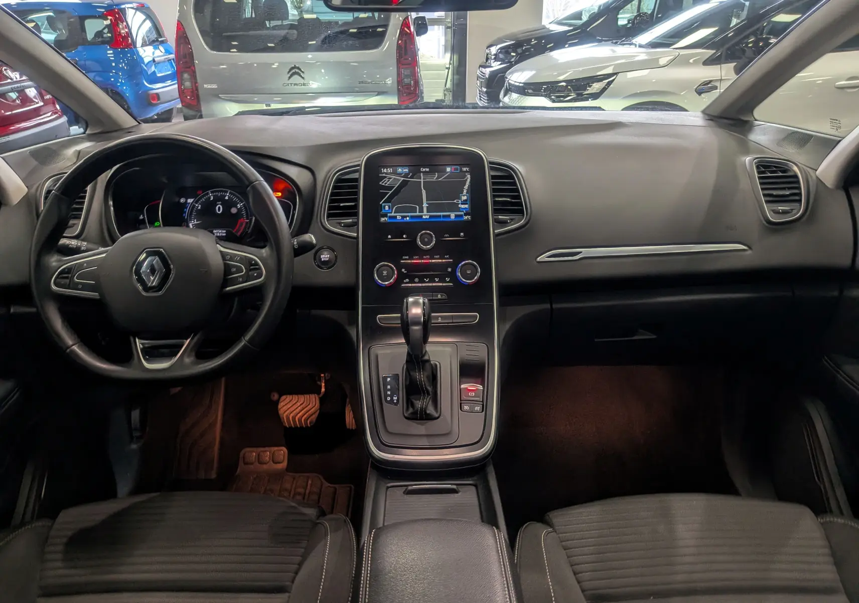 Vue intérieure frontale du tableau de bord et console centrale du Renault Grand Scenic IV TCe 140 Gris Cassiopé, avec écran tactile et volant multifonction.