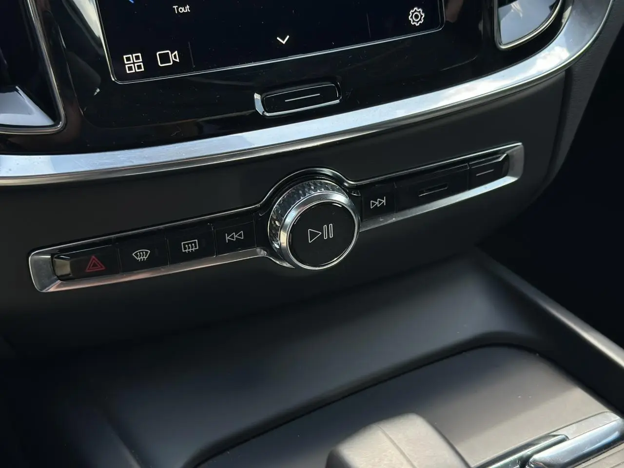 Détail de la console centrale noire de la Volvo S60 2024 avec commandes multimédia et bouton de lecture.