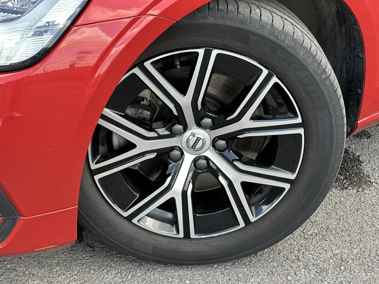 Gros plan sur la jante alliage 17 pouces noir et diamant du côté avant gauche d’une Volvo S60 Rouge Fusion 2024.