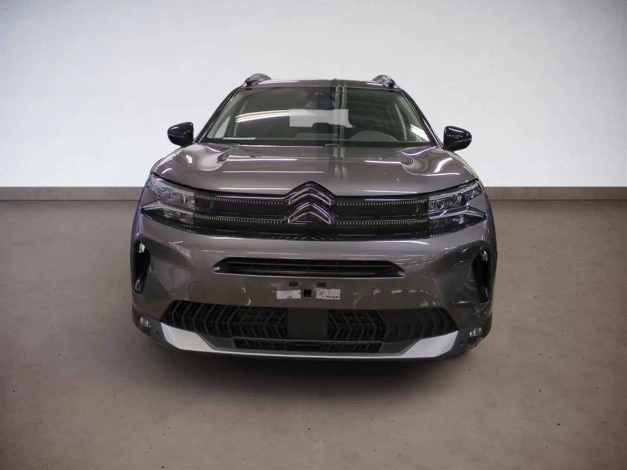 Vue frontale d'un Citroën C5 Aircross Hybrid 145 gris Platinium avec calandre noire et phares LED fins.