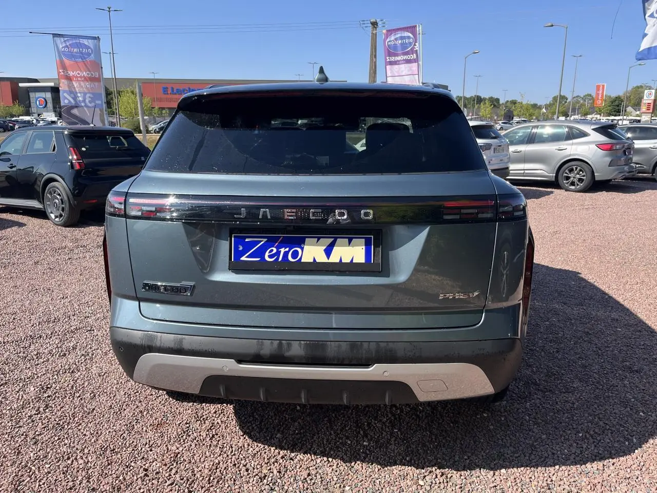 Vue arrière d'un JAECOO J7 gris olive 2026 avec feux LED horizontaux et plaque d'immatriculation Zero KM visible.