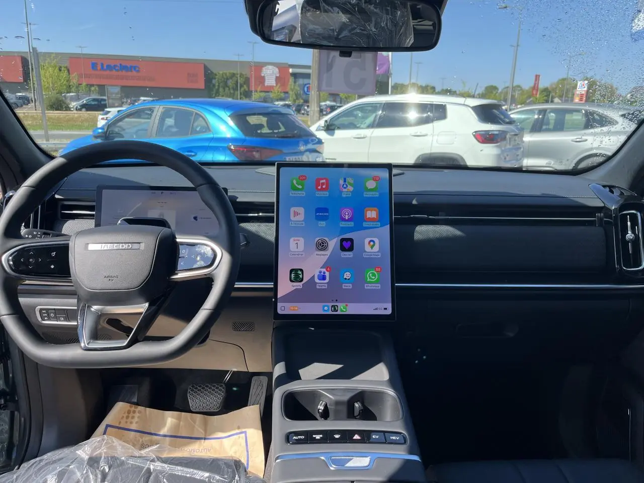Vue intérieure avant du JAECOO J7 gris olive 2026, avec grand écran tactile vertical et volant multifonction.