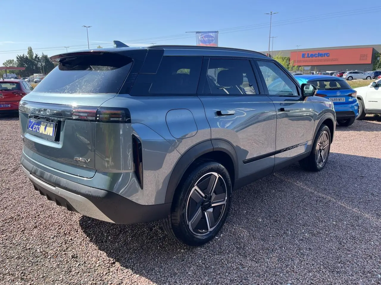 Vue 3/4 arrière droite du SUV JAECOO J7 gris olive avec toit noir, vitres surteintées et jantes modernes.