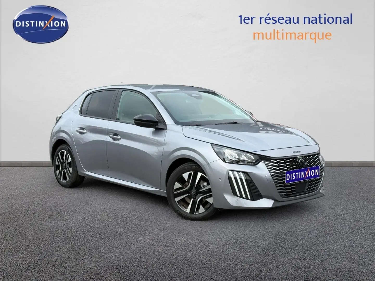 Peugeot 208 gris Artense vue 3/4 avant droit, avec jantes alliage et calandre distinctive noire.