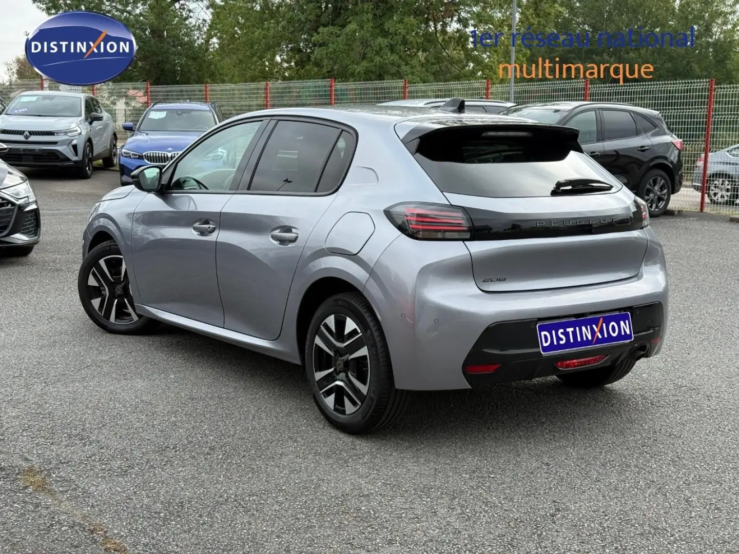 Vue 3/4 arrière droite d'une Peugeot 208 1.2 100ch gris Artense avec jantes alu et vitres teintées en extérieur.