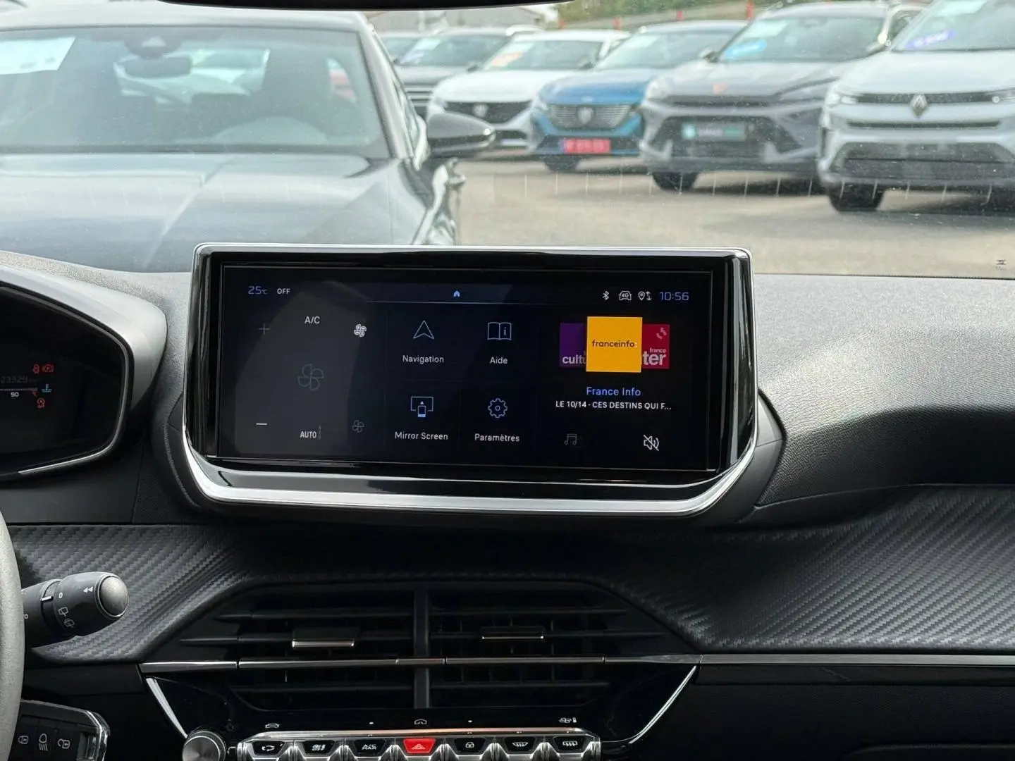 Vue intérieure centrée sur l'écran tactile du tableau de bord de la Peugeot 208 gris Artense, avec détails carbone.