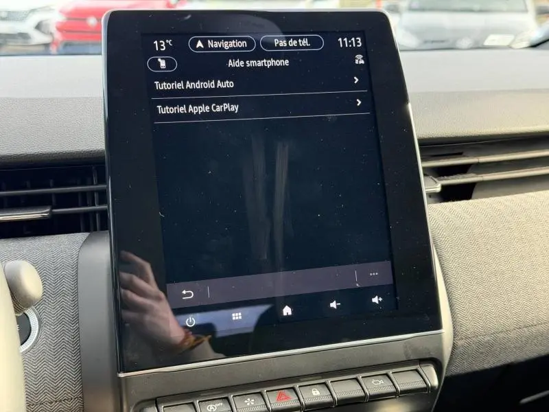 Écran tactile central de la Renault Clio 1.0 Eco-G 2025 affichant tutoriels Android Auto et Apple CarPlay.