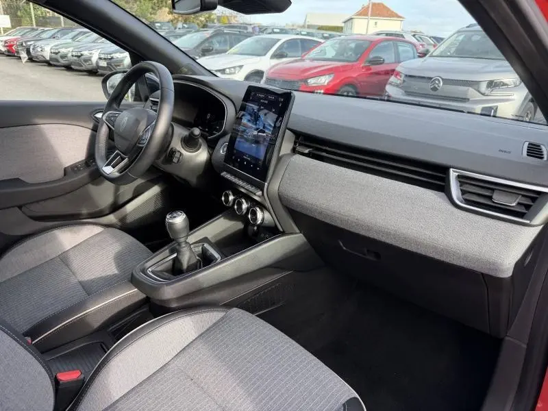 Vue intérieure côté passager de la Renault Clio 1.0 Eco-G 100ch Techno 2025 avec tableau de bord gris et écran tactile vertical.