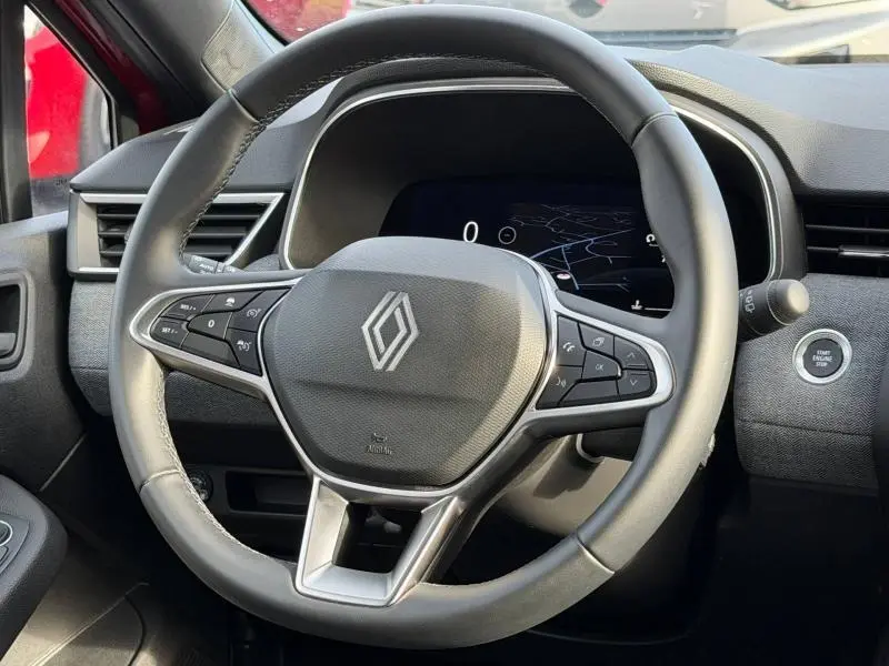 Vue rapprochée du volant multifonction noir de la Renault Clio 1.0 Eco-G 2025 avec tableau de bord numérique et bouton start/stop.