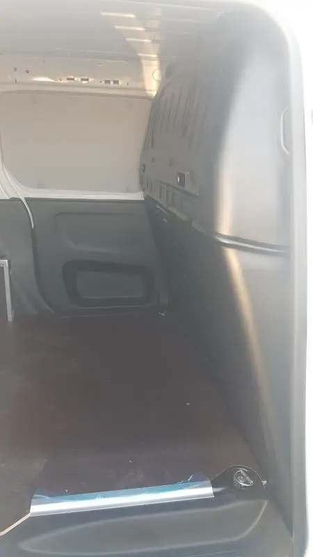 Vue intérieure de la zone de chargement du Citroën Berlingo blanc 2025, montrant l’espace vide et la cloison noire.
