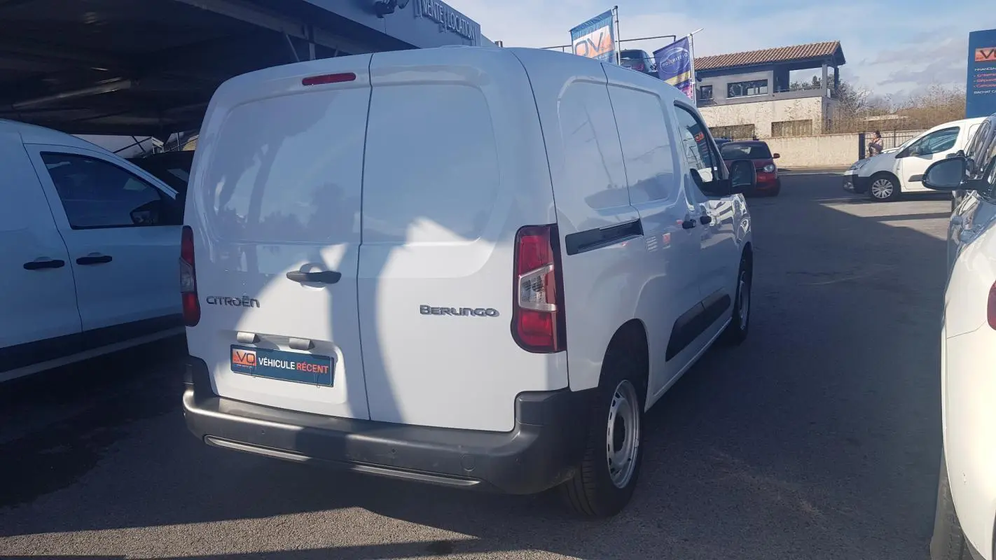 Vue 3/4 arrière droite d’un utilitaire blanc Citroën Berlingo Van 2025 avec porte latérale et jantes acier 15 pouces.