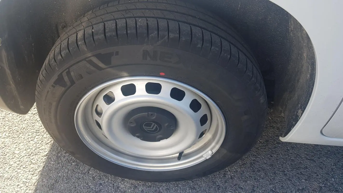 Gros plan sur la roue avant droite blanche d’un Citroën Berlingo 2025 avec jante acier 15 pouces.