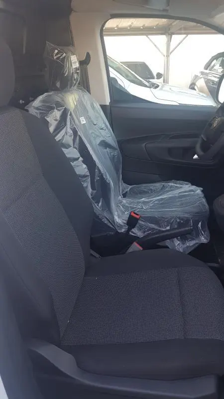 Vue intérieure côté droit du siège conducteur du Citroën Berlingo blanc 2025, siège protégé par film plastique.