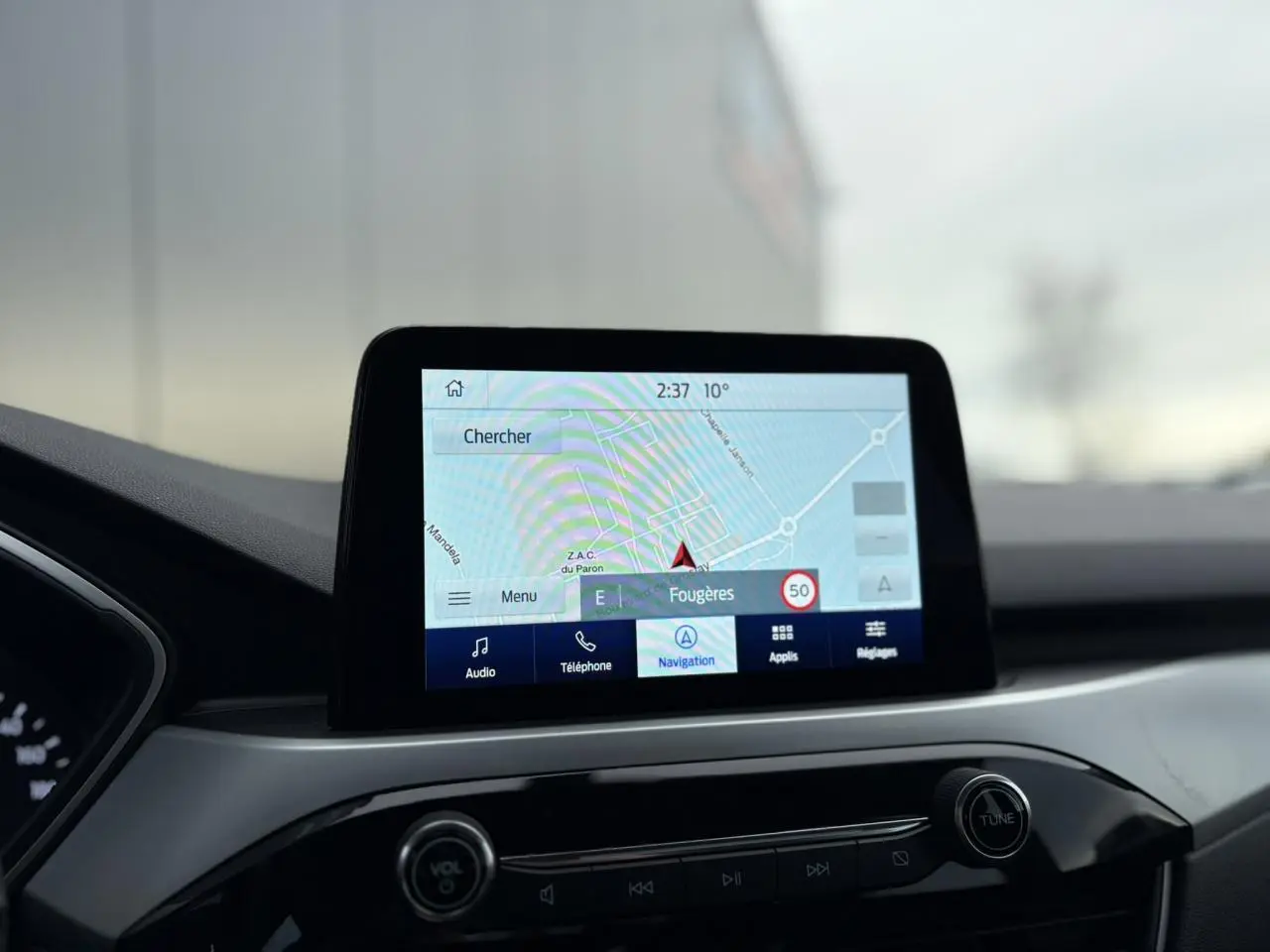 Écran tactile du GPS SYNC 4 du Ford Kuga 2024, vue intérieure centrée sur la console et le tableau de bord.