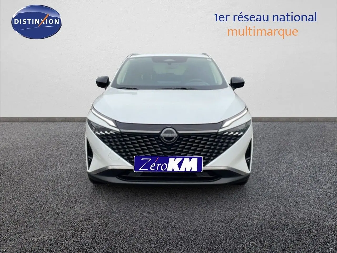 Vue frontale d'un Nissan Qashqai 2025 blanc nacré avec calandre noire et phares LED fins.