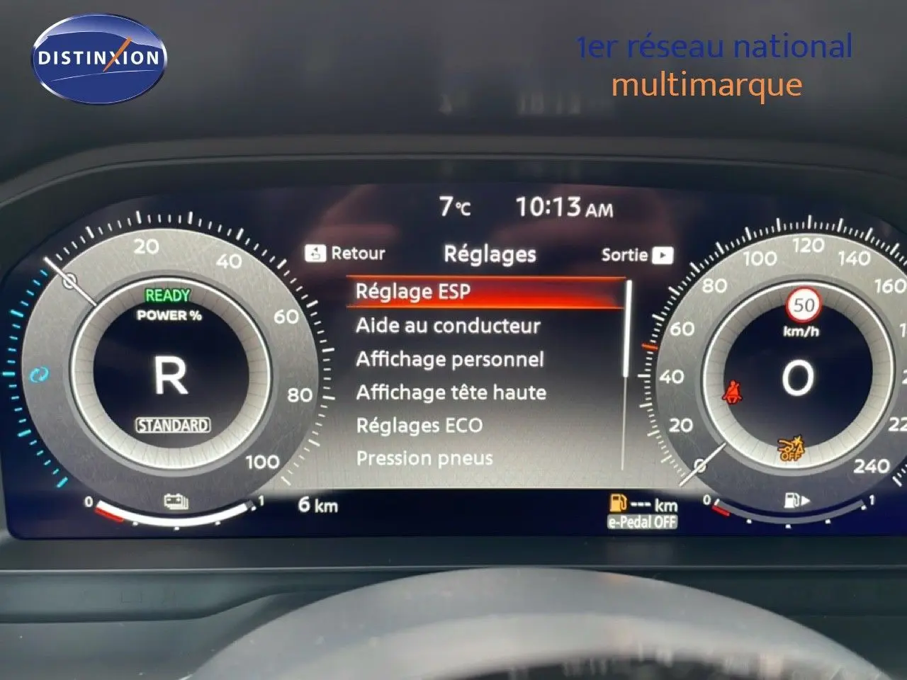 Tableau de bord numérique du Nissan Qashqai blanc nacré, affichant les réglages et compteurs en vue frontale.