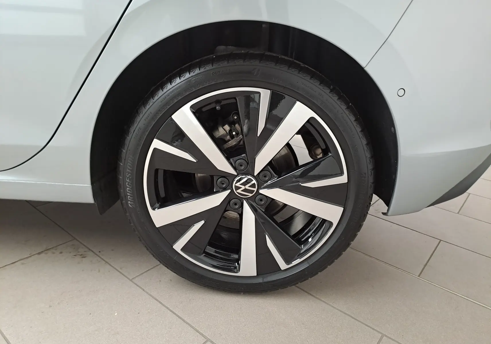 Gros plan sur la jante alliage 18'' Catania noire et argent du côté arrière droit d'une Volkswagen Golf Argent Dolomite.