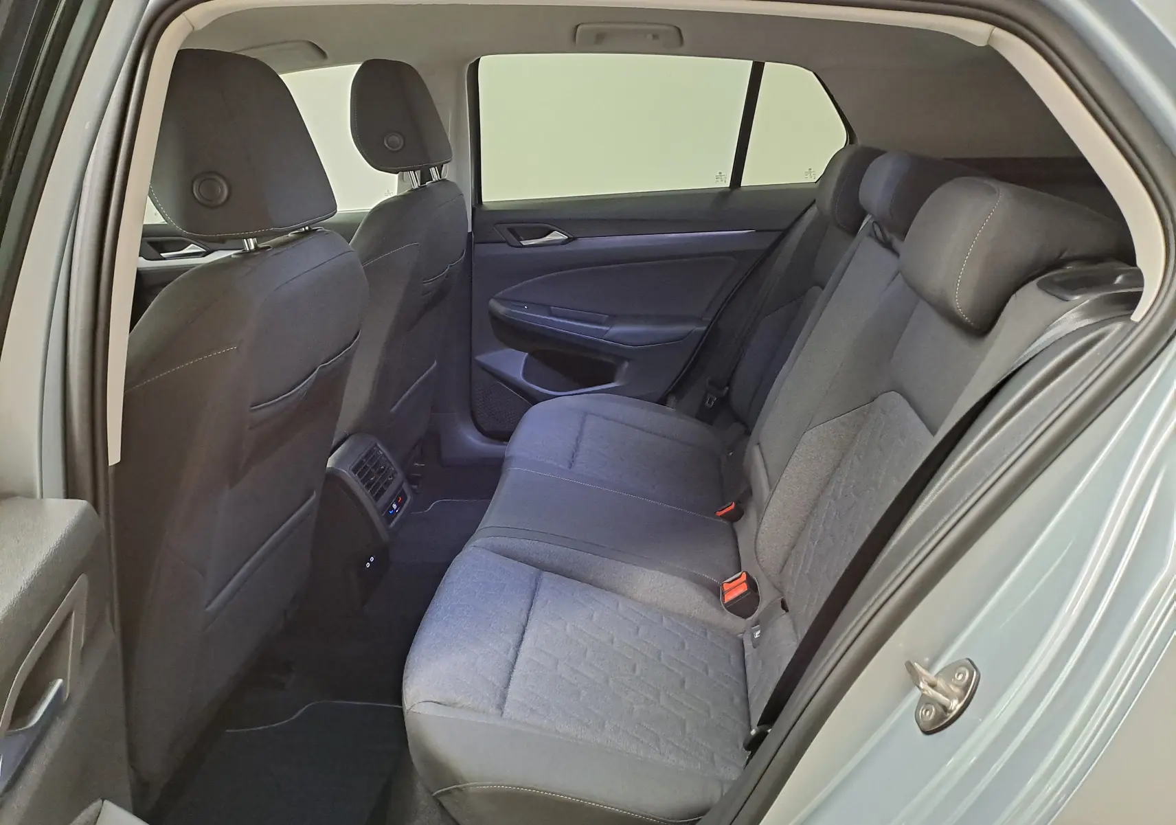 Vue intérieure arrière côté droit de la Volkswagen Golf 1.5 eTSI 116 BVM6 VW Edition 2025 avec sièges tissu gris et portière ouverte.