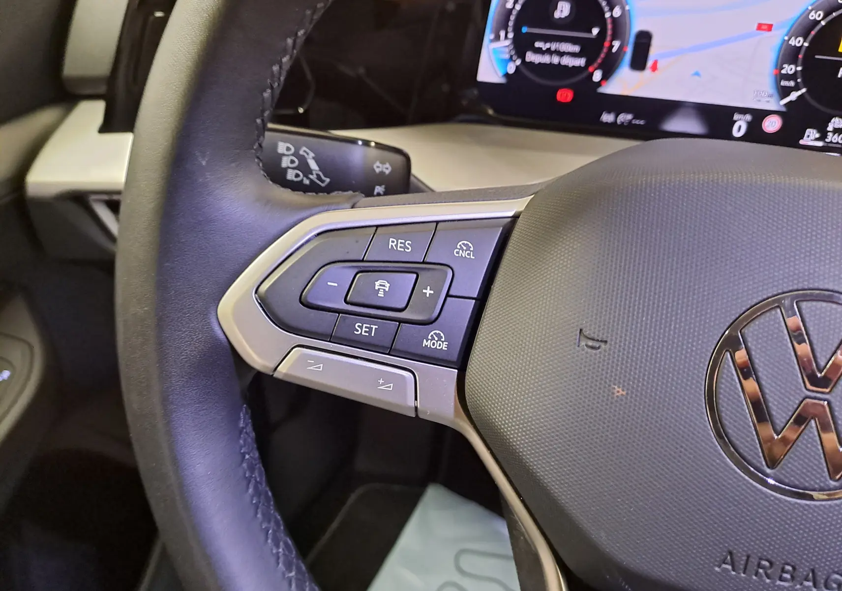 Gros plan sur le volant de la Volkswagen Golf 1.5 eTSI 2025, avec commandes multifonctions et tableau de bord numérique.
